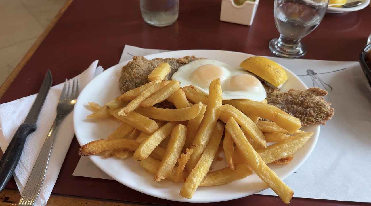 A classic milanesa with fries and fried eggs